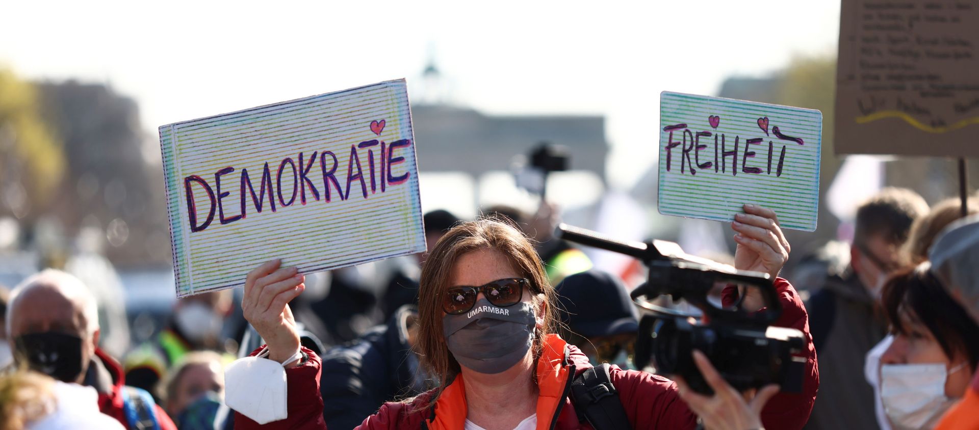 A demonstrator holds up signs reading democracy and freedom during a protest against the government measures to curb the spread of the coronavirus disease (COVID-19), on the day of discussion in the lower house of parliament Bundestag regarding additions for the Infection Protection Act, in Berlin, Germany April 21, 2021 - Sputnik International, 1920