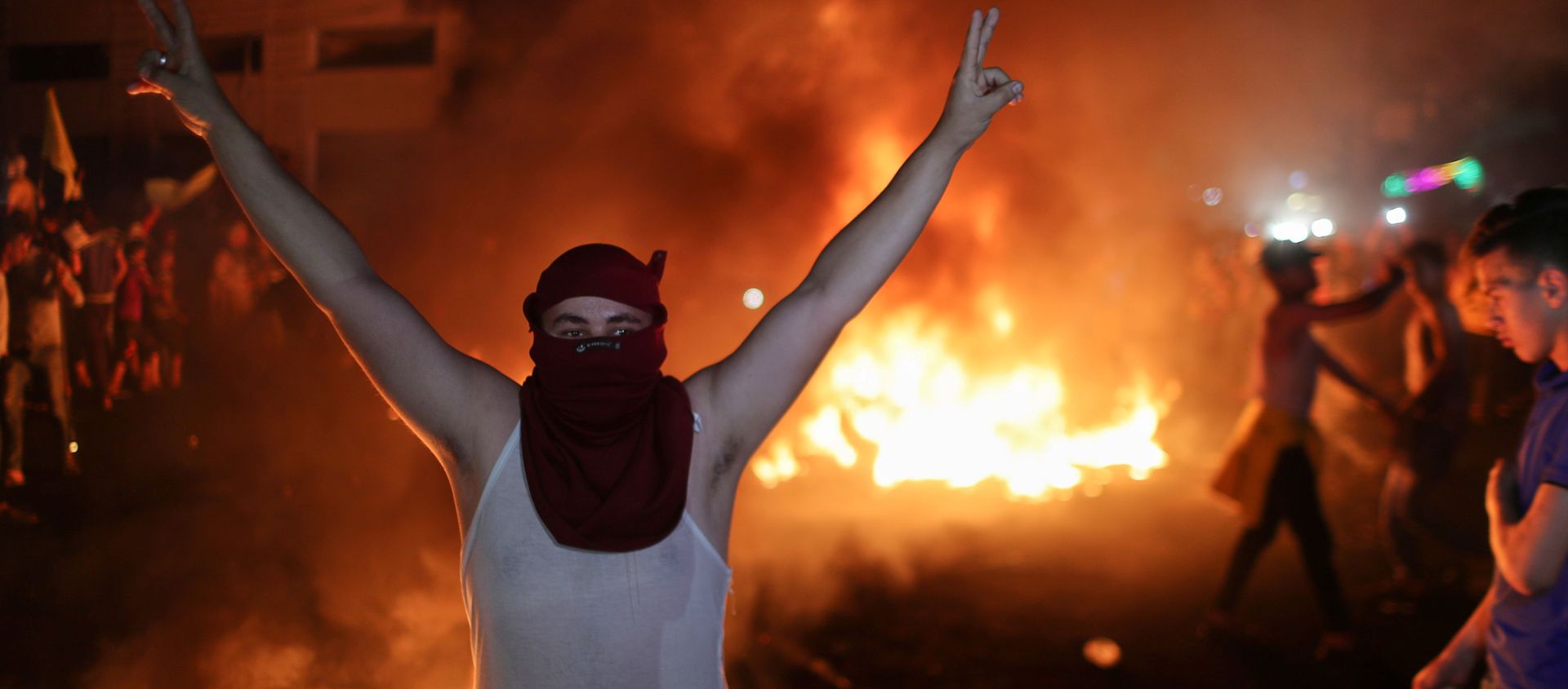 A Palestinian demonstrator gestures as tires burn during an anti-Israel protest over tension in Jerusalem, in Gaza City April 24, 2021.  - Sputnik International, 1920, 25.04.2021