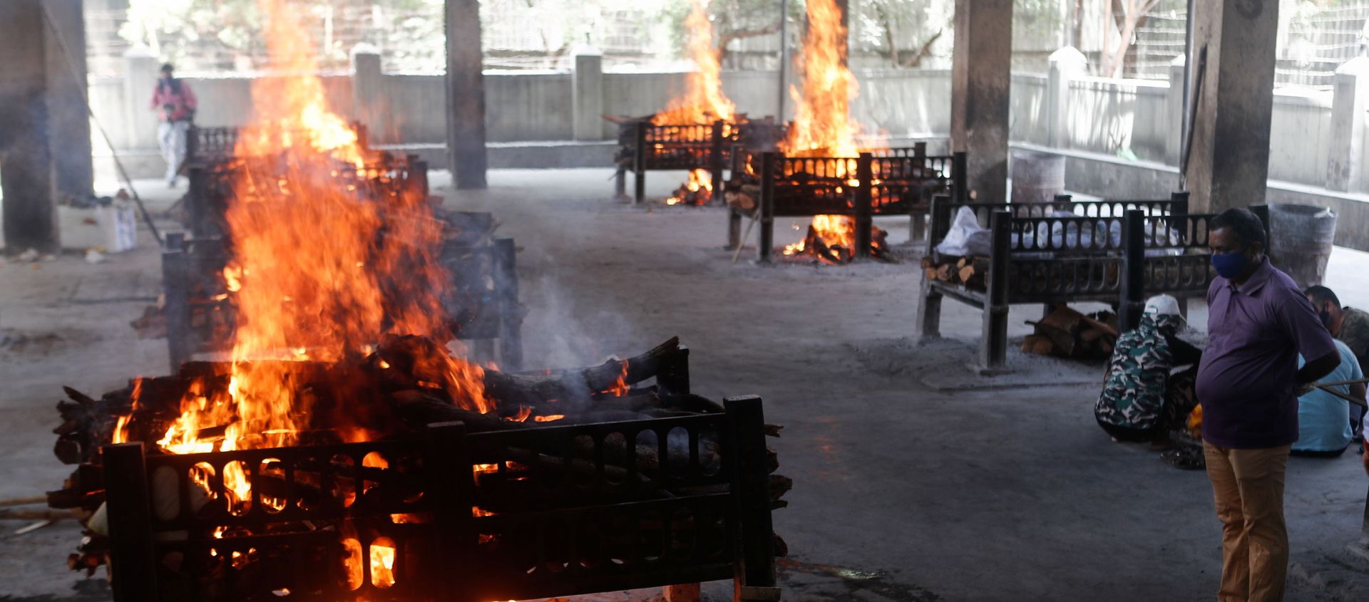 A relative of a coronavirus disease (COVID-19) patient who passed away after a hospital caught fire looks on as funeral pyres burn inside a crematorium in Virar, on the outskirts of Mumbai, India, 23 April 2021 A relative of a coronavirus disease (COVID-19) patient who passed away after a hospital caught fire looks on as funeral pyres burn inside a crematorium in Virar, on the outskirts of Mumbai, India, 23 April 2021 - Sputnik International, 1920, 29.04.2021