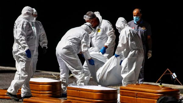 Rescuers from the Spanish Coast Guard place one of the recovered bodies of four deceased migrants into a coffin at the port of La Restinga, on the Canary Island of El Hierro - Sputnik International