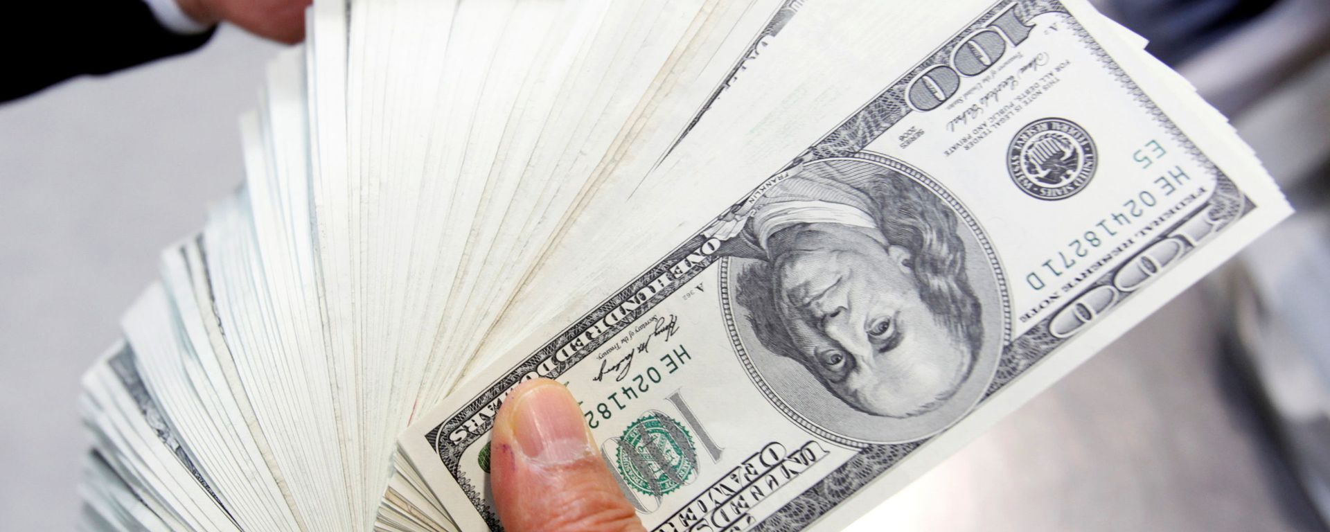 An employee of the Korea Exchange Bank counts one hundred U.S. dollar notes during a photo opportunity at the bank's headquarters in Seoul April 28, 2010 - Sputnik International, 1920, 03.06.2021