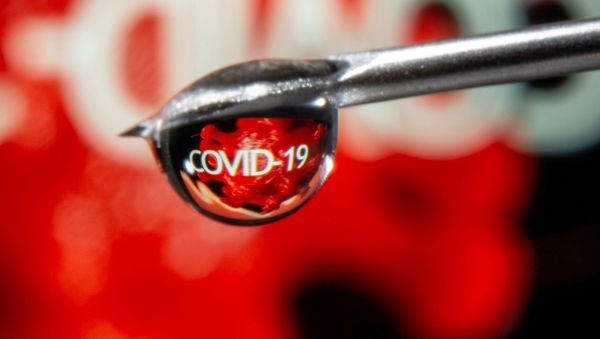 FILE PHOTO: The word COVID-19 is reflected in a drop on a syringe needle in this illustration taken November 9, 2020. - Sputnik International