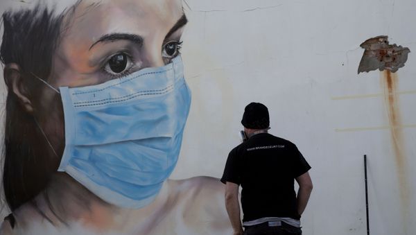 Graffiti artist Bram De Ceurt takes a step back as he works on a street graffiti piece of a nurse with a mouth mask to protect against coronavirus in Antwerp, Belgium, Thursday, March 26, 2020 - Sputnik International