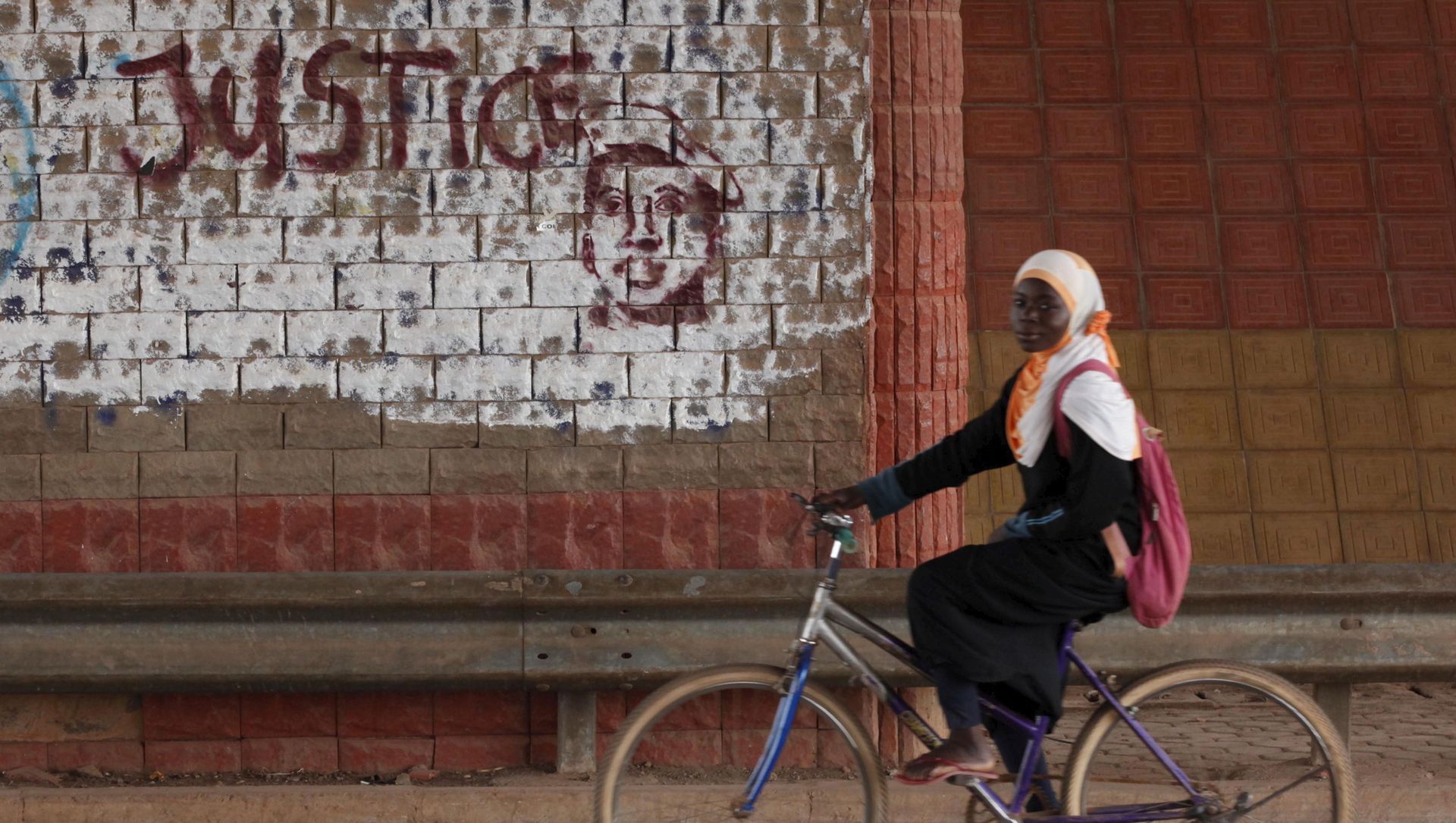 A girl rides a bicycle past graffiti reading Justice with a picture of slain ex-President Thomas Sankara in Ouagadougou, Burkina Faso, December 4, 2015. A girl rides a bicycle past graffiti reading Justice with a picture of slain ex-President Thomas Sankara in Ouagadougou, Burkina Faso, December 4, 2015. - Sputnik International, 1920, 28.04.2021