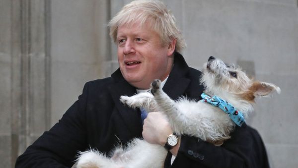 Britain's Prime Minister and Conservative Party leader Boris Johnson holds his dog Dilyn as he leaves after voting in the general election at Methodist Central Hall, Westminster, London, 12 December 2019 - Sputnik International
