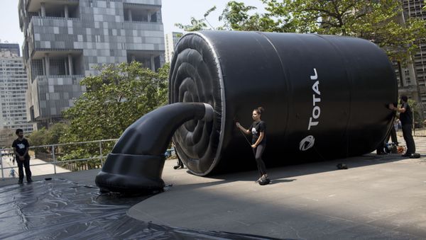 Greenpeace activists stand by an inflatable structure mimicking a barrel spilling oil as they protest outside France's Total oil company's headquarters in Rio de Janeiro, Brazil, Thursday, Sept. 28, 2017 - Sputnik International