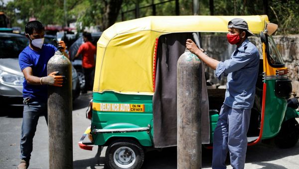  Rickshaw drivers hold oxygen cylinders outside a private refilling station, amid the coronavirus disease (COVID-19) outbreak, in New Delhi, India, April 19, 2021 - Sputnik International