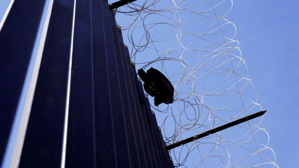 A shirt from a migrant hangs on razor wire at the US border with Mexico in Calexico, California, US, 8 April 2021. A shirt from a migrant hangs on razor wire at the US border with Mexico in Calexico, California, US, 8 April 2021. - Sputnik International