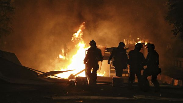 Riot police walk towards a burning barricade set up by protesters during a national strike to protest government-proposed tax reform, in Cali, Colombia, Friday, April 30, 2021 - Sputnik International