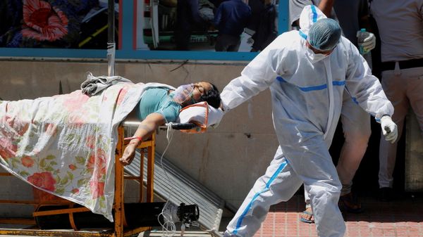 FILE PHOTO: A health worker wearing personal protective equipment (PPE) carries a patient suffering from the coronavirus disease (COVID-19) outside the casualty ward at Guru Teg Bahadur hospital, in New Delhi, India on 24 April 2021. - Sputnik International