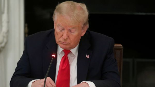 U.S. President Donald Trump is seen tapping the screen on a mobile phone during a roundtable discussion on the reopening of small businesses in the State Dining Room at the White House in Washington, U.S., June 18, 2020 - Sputnik International