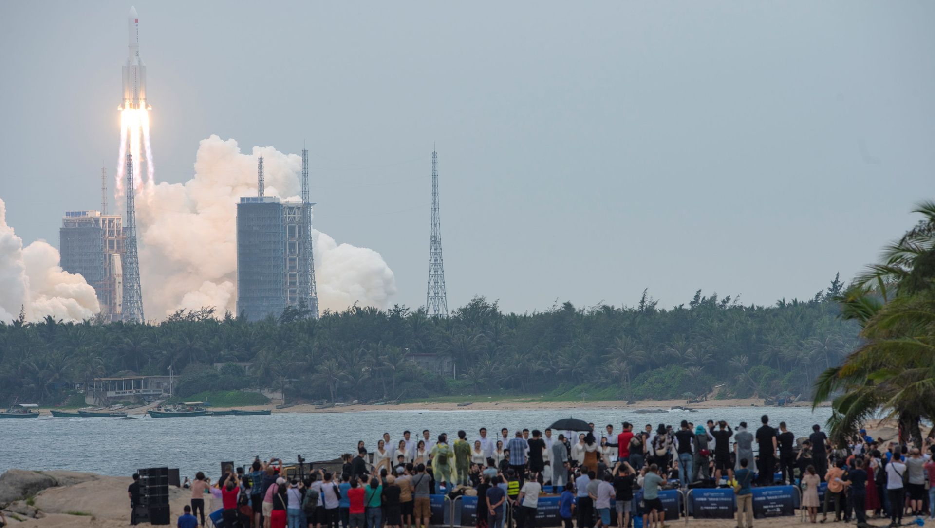 People watch from a beach as the Long March-5B Y2 rocket, carrying the core module of China's space station Tianhe, takes off from Wenchang Space Launch Center in Hainan province, China April 29, 2021.  - Sputnik International, 1920, 05.05.2021