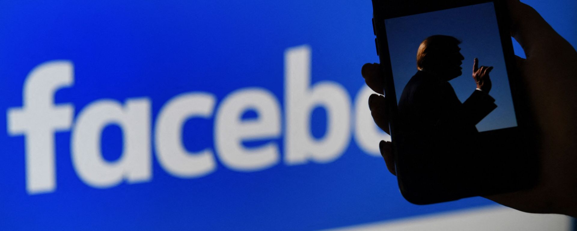 In this file photo illustration, a phone screen displays a picture of former US President Donald Trump on a Facebook website background, on May 4, 2021, in Arlington, Virginia. - Facebook's independent oversight board on May 5, 2021 upheld the platform's ban on former US president Donald Trump but called for a further review of the penalty within six months. The board, whose decisions are binding on the leading social network, said Trump created an environment where a serious risk of violence was possible with his comments regarding the January 6 rampage by his supporters at the US Capitol. - Sputnik International, 1920, 05.06.2021
