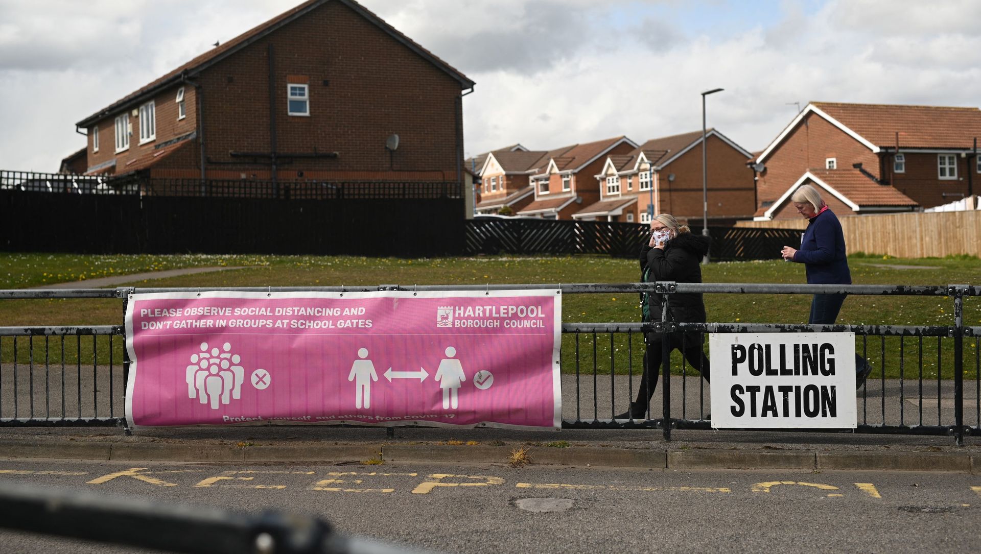 People walk past banners for a polling station in Hartlepool, County Durham on 6 May 2021, as voters cast their ballots in local elections. People walk past banners for a polling station in Hartlepool, County Durham on 6 May 2021, as voters cast their ballots in local elections. - Sputnik International, 1920, 12.05.2021
