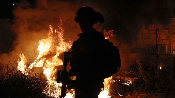 Israeli security looks on as they stand by a burning settlers car in the Sheikh Jarrah neighbourhood of Israeli-annexed east Jerusalem on May 6, 2021, amidst confrontations between Israeli security and Palestinian demonstrators in solidarity with local Palestinian families facing eviction as part of an ongoing effort by Jewish Israelis to take control of homes in the neighbourhood.  - Sputnik International