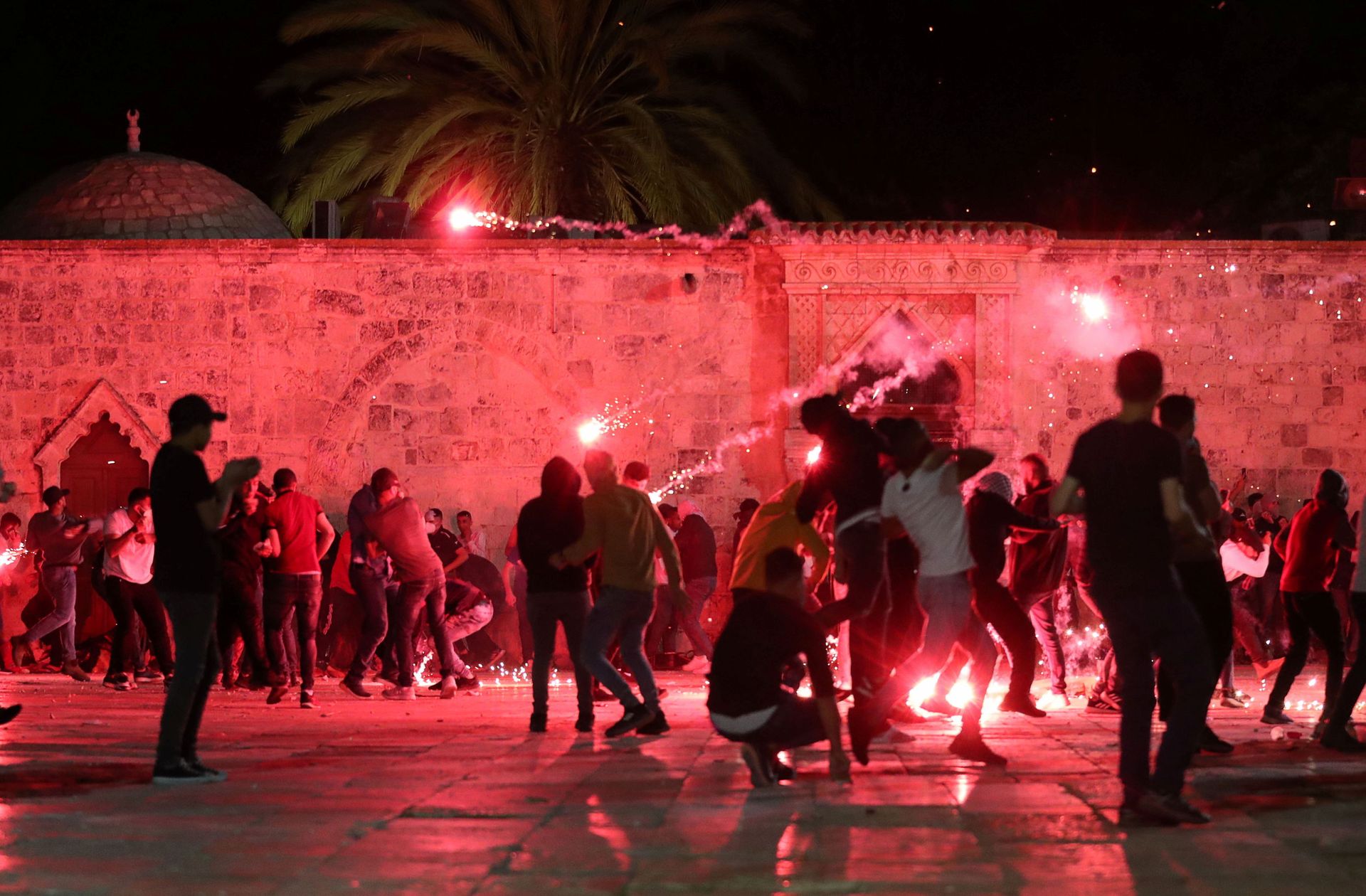 Palestinians react as Israeli police fire stun grenades during clashes at the compound that houses Al-Aqsa Mosque, known to Muslims as Noble Sanctuary and to Jews as Temple Mount, amid tension over the possible eviction of several Palestinian families from homes on land claimed by Jewish settlers in the Sheikh Jarrah neighbourhood, in Jerusalem's Old City, May 7, 2021 - Sputnik International, 1920, 16.01.2022