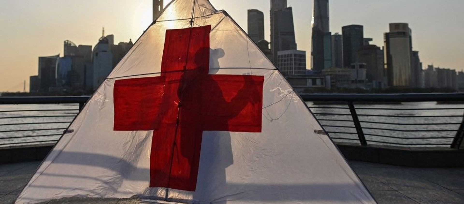This picture taken on March 23, 2020 shows Gu, 80, wearing a facemask as a preventive measure against the spread of the COVID-19 novel coronavirus, as he prepares to fly his kite in the early morning on the promenade of the Bund along Huangpu River in Shanghai. - Sputnik International, 1920, 09.05.2021