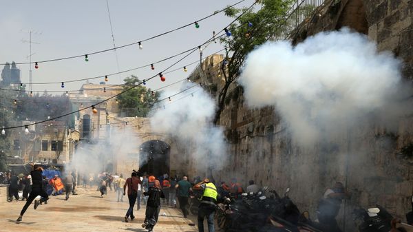 Palestinians run away as Israeli police fire a stun grenade during clashes at the compound that houses Al-Aqsa Mosque, known to Muslims as Noble Sanctuary and to Jews as Temple Mount, in Jerusalem's Old City, May 10, 2021.  - Sputnik International
