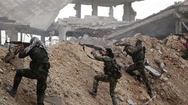 In this Dec. 5, 2016 file photo, Syrian army soldiers fire their weapons during a battle with rebel fighters at the Ramouseh front line, east of Aleppo, Syria. - Sputnik International