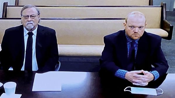 In this image made from video, from left, father and son, Gregory and Travis McMichael, accused in the shooting death of Ahmaud Arbery in Georgia on Feb. 2020, listen via closed circuit tv in the Glynn County Detention center in Brunswick, Ga., on Thursday, Nov. 12, as lawyers argue for bond to be set at the Glynn County courthouse.  - Sputnik International