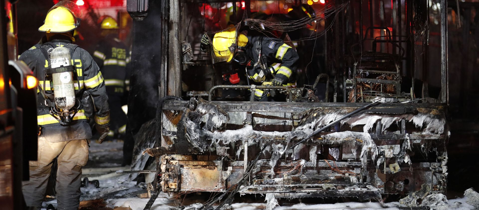Israeli firefighters check out a burnt bus in the Israeli town of Holon near Tel Aviv, on May 11, 2021, after rockets are launched towards Israel from the Gaza Strip controlled by the Palestinian Hamas movement - Sputnik International, 1920, 12.05.2021