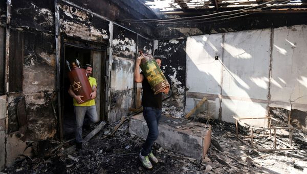 Torah scrolls, Jewish holy scriptures, are removed from a synagogue which was torched during violent confrontations in the city of Lod, Israel between Israeli Arab demonstrators and police, amid high tensions over hostilities between Israel and Gaza militants and tensions in Jerusalem May 12, 2021 - Sputnik International