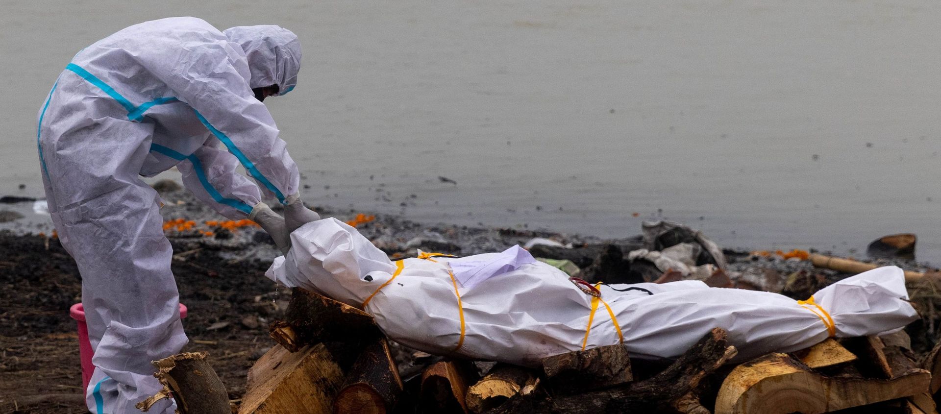 A man wearing a protective suit touches the body of his relation, who died from the coronavirus disease (COVID-19), before his cremation on the banks of the river Ganges at Garhmukteshwar in the northern state of Uttar Pradesh, India on 6 May 2021. A man wearing a protective suit touches the body of his relation, who died from the coronavirus disease (COVID-19), before his cremation on the banks of the river Ganges at Garhmukteshwar in the northern state of Uttar Pradesh, India on 6 May 2021. - Sputnik International, 1920, 04.09.2021