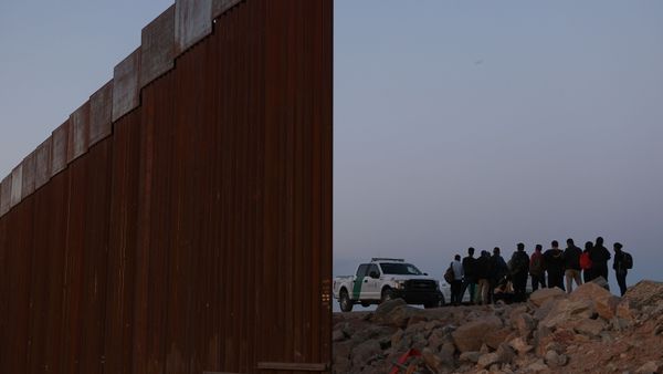 Asylum seekers are detained by U.S. Border Patrol at the border wall after crossing into the United States near Yuma - Sputnik International