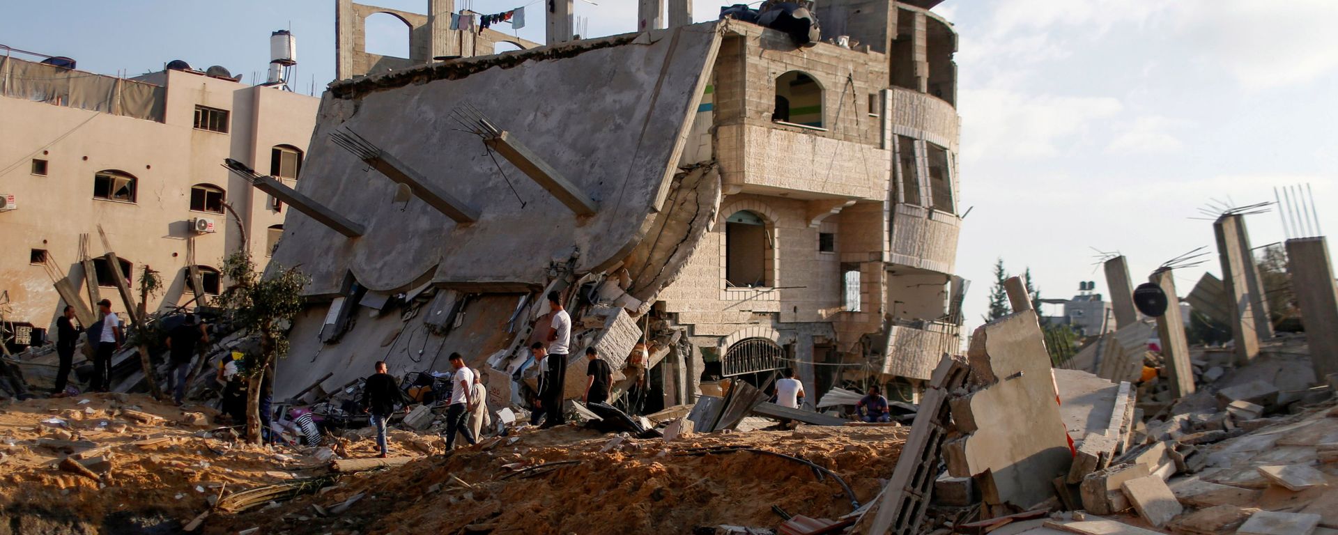 Palestinians gather around the ruins of buildings which were destroyed in Israeli air strikes amid a flare-up of Israeli-Palestinian violence, in the northern Gaza Strip May 13, 2021. - Sputnik International, 1920