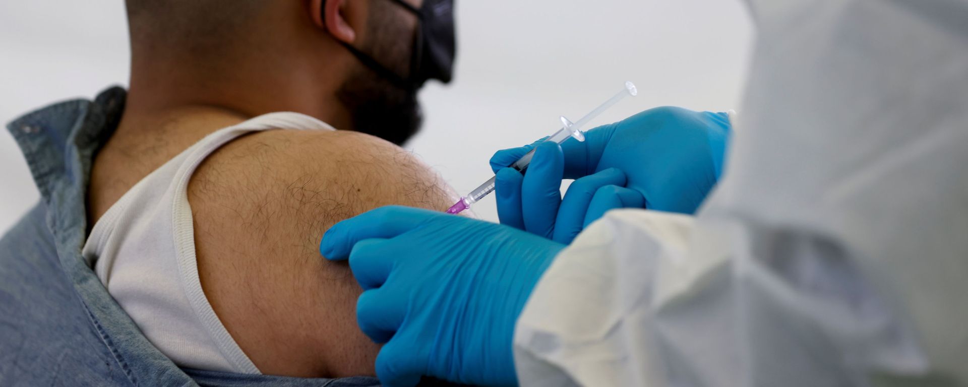 A person receives a vaccine against the coronavirus disease (COVID-19) at a sports hall in Berlin, Germany, May 14, 2021. - Sputnik International, 1920, 28.11.2021