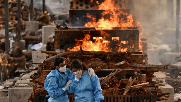 FILE PHOTO: Family members of Vijay Raju, who died due to the coronavirus disease (COVID-19), mourn before his cremation at a crematorium ground in Giddenahalli village on the outskirts of Bengaluru, India, May 13, 2021. - Sputnik International