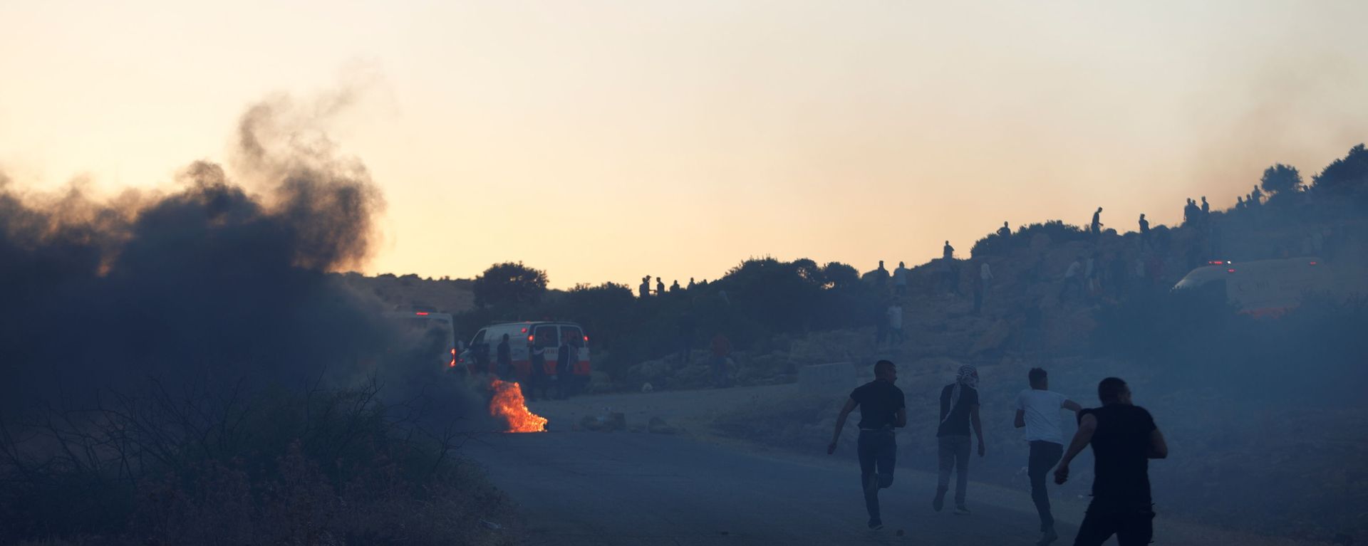 Palestinian demonstrators run towards an ambulance during a protest over tension in Jerusalem and Israel-Gaza escalation, near Tubas in the Israeli-occupied West Bank, May 15, 2021. - Sputnik International, 1920