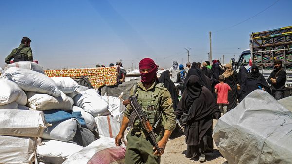 A member of Kurdish security watches preparations as another group of Syrian families is released from the Kurdish-run Al-Hol camp, which holds relatives of suspected Islamic State (IS) group fighters, in the northeastern Syrian Hasakeh governorate, on May 11, 2021 - Sputnik International