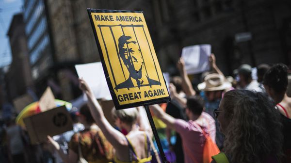 A protester holds a placard featuring US President Donald Trump behinid bars during the so-called Helsinki Calling march towards the Senate Square to defend the human rights, freedom of speech and democracy on July 15, 2018 - Sputnik International