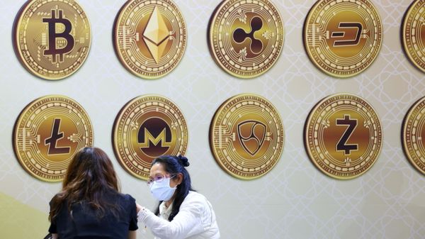Customers talk against a backboard with signs of cryptocurrency during 2020 Taipei International Finance Expo in Taipei, Taiwan, November 27, 2020. REUTERS/Ann Wang/File Photo - Sputnik International