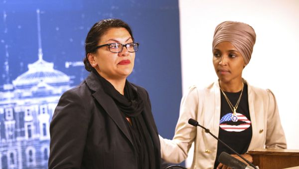 Rep. Ilhan Omar, right, (D-Minn) consoles Rep. Rashida Tlaib (D-MI) as she talk about Israel's refusal to allow them to visit the country during a news conference Monday, Aug. 19, 2019 at the State Capitol in St. Paul, Minn. - Sputnik International