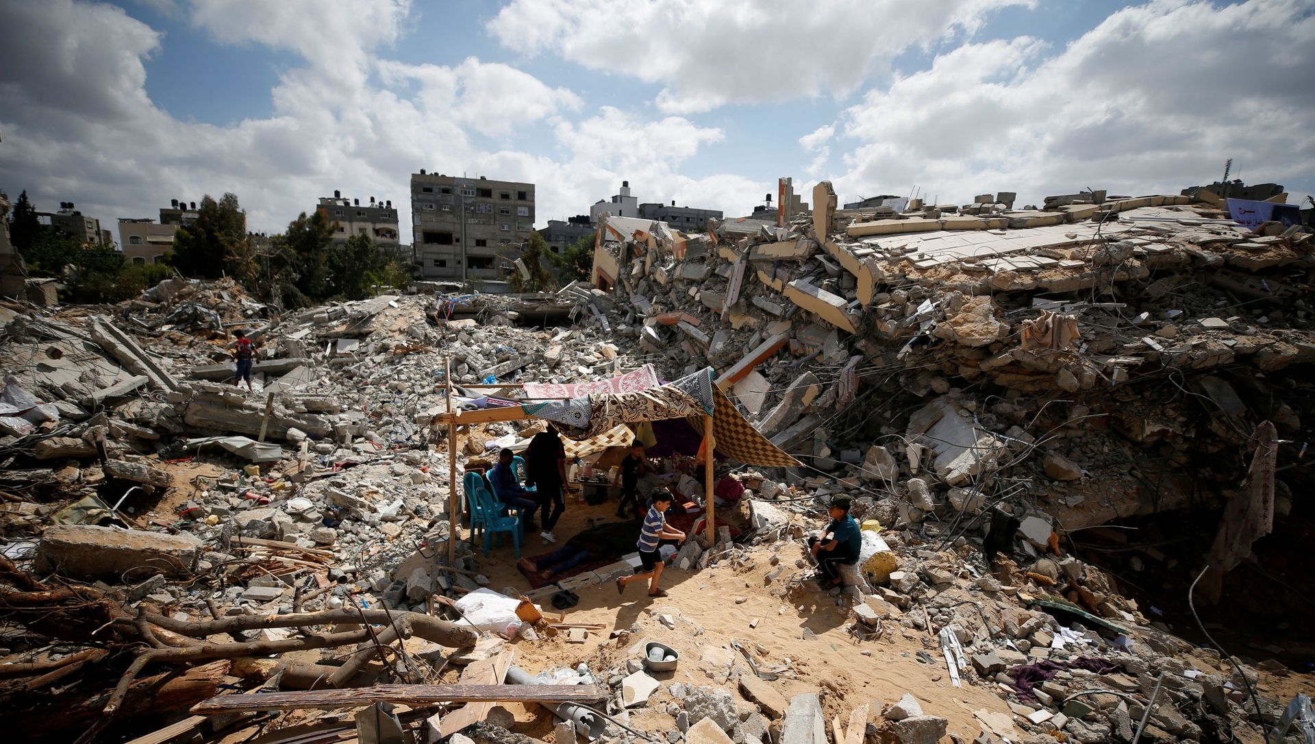 Palestinians sit in a makeshift tent amid the rubble of their houses, which were destroyed by Israeli air strikes during the Israel-Hamas fighting in Gaza, 23 May 2021. REUTERS/Mohammed Salem TPX IMAGES OF THE DAY Palestinians sit in a makeshift tent amid the rubble of their houses, which were destroyed by Israeli air strikes during the Israel-Hamas fighting in Gaza, 23 May 2021. REUTERS/Mohammed Salem TPX IMAGES OF THE DAY - Sputnik International, 1920, 24.05.2021
