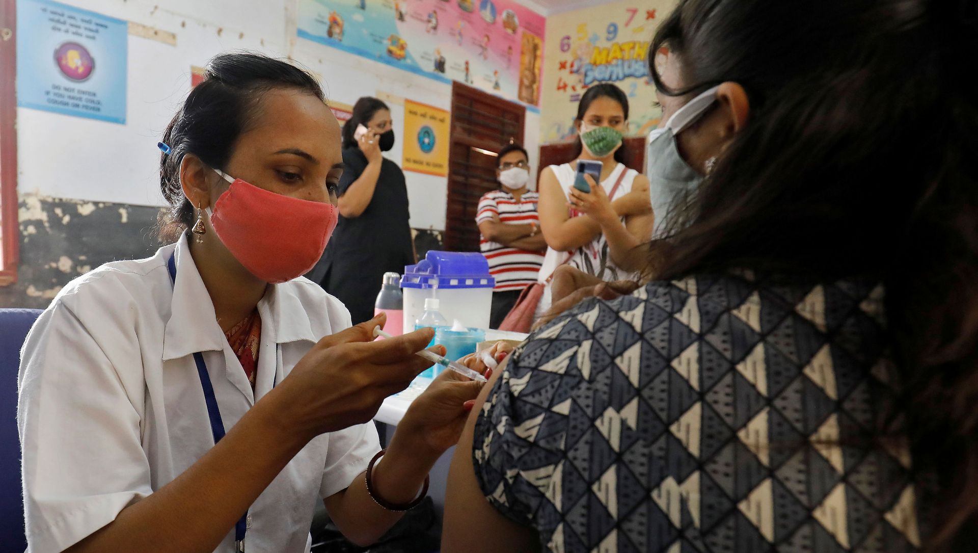 A healthcare worker gives a dose of COVISHIELD, a coronavirus disease (COVID-19) vaccine manufactured by Serum Institute of India, to a woman inside a classroom of a school, which has been converted into a temporary vaccination centre, in Ahmedabad, India, May 1, 2021 A healthcare worker gives a dose of COVISHIELD, a coronavirus disease (COVID-19) vaccine manufactured by Serum Institute of India, to a woman inside a classroom of a school, which has been converted into a temporary vaccination centre, in Ahmedabad, India, May 1, 2021 - Sputnik International, 1920, 24.06.2021
