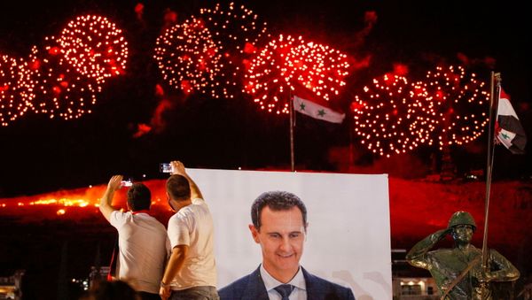 A poster depicting Syria’s president Bashar al- Assad is seen as supporters of of Syria's President Bashar al-Assad celebrate after the results of the presidential election announced that he won a fourth term in office, in Damascus, Syria, May 27, 2021. - Sputnik International