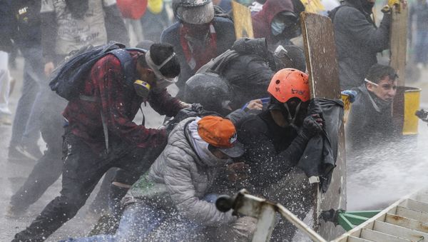 Anti-government protesters take cover from a police water cannon during clashes in Madrid, on the outskirts of Bogota, Colombia, Friday, May 28, 2021.  - Sputnik International