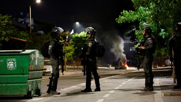 sraeli Border Police force members stand near burning tires by one of the entrances to the Arab-Jewish town of Lod, Israel May 13, 2021 - Sputnik International