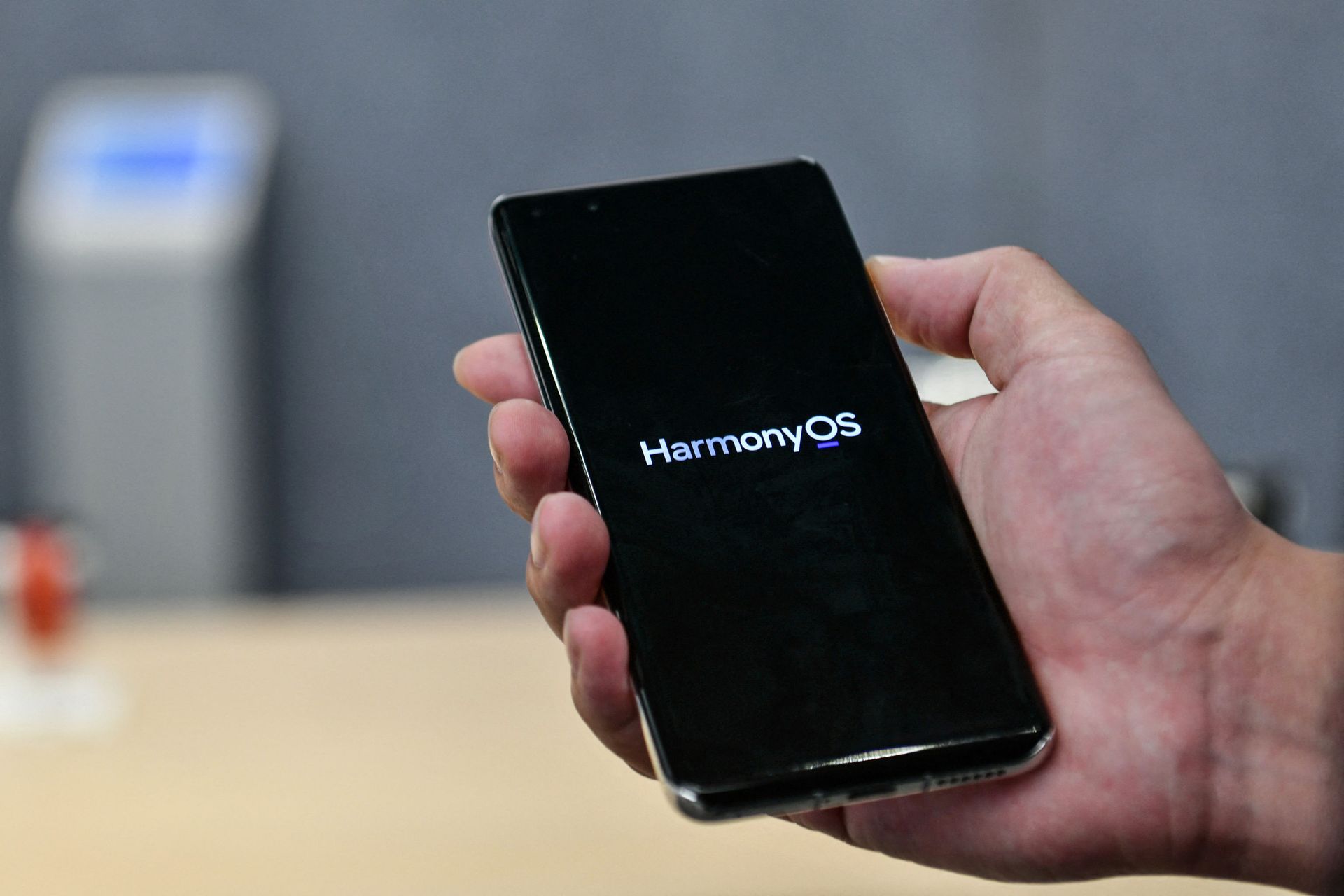This photo taken on May 31, 2021 shows a staff member displaying a Huawei smartphone with the HarmonyOS operating system at the Huawei flagship store in Shenzhen, in China's southern Guangdong province. - Sputnik International, 1920, 07.09.2021