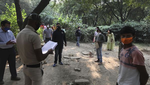 A Delhi police volunteer hands out COVID-19 test results in New Delhi, India, Friday, Nov. 6, 2020 - Sputnik International