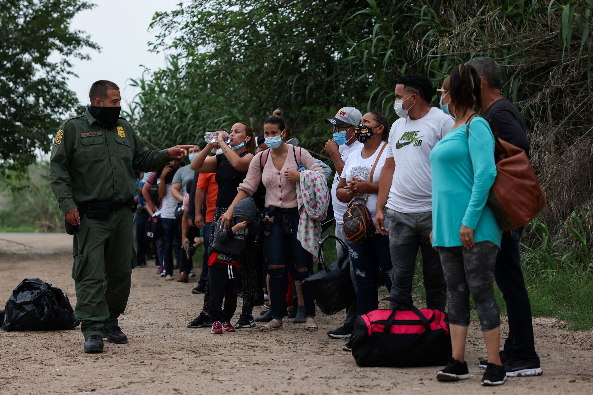 Migrants from Venezuela await transportation to a U.S. border patrol facility after crossing the Rio Grande river into the United States from Mexico in Del Rio, Texas, U.S., May 11, 2021 - Sputnik International, 1920, 07.09.2021