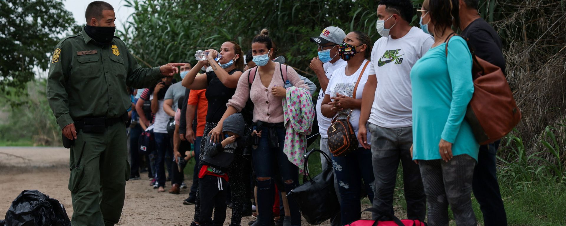 Migrants from Venezuela await transportation to a U.S. border patrol facility after crossing the Rio Grande river into the United States from Mexico in Del Rio, Texas, U.S., May 11, 2021 Migrants from Venezuela await transportation to a U.S. border patrol facility after crossing the Rio Grande river into the United States from Mexico in Del Rio, Texas, U.S., May 11, 2021 - Sputnik International, 1920, 04.06.2021