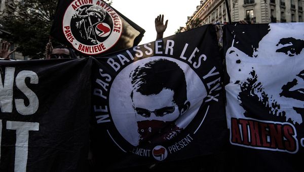 Demonstrators hold a banner carrying a picture of the late anti-fascist protestor Clement Meric as they stage a protest in Paris on September 14, 2018, co-inciding with the end of the trial of three men accused of killing Meric in a clash in 2013. - Sputnik International