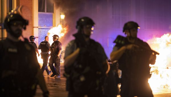 Police stand guard after protesters set fire to dumpsters after a vigil was held for Winston Boogie Smith Jr. early on Saturday, June 5, 2021.  - Sputnik International