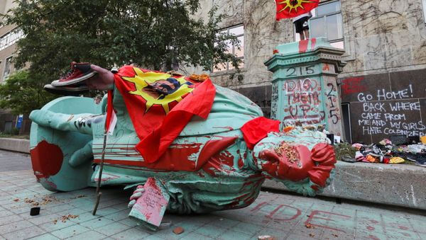A person stands on a plinth after the defaced statue of Egerton Ryerson, considered an architect of Canada's residential indigenous school system, lies on the pavement after being toppled following a protest at Ryerson University in Toronto, Ontario, Canada June 6, 2021 - Sputnik International