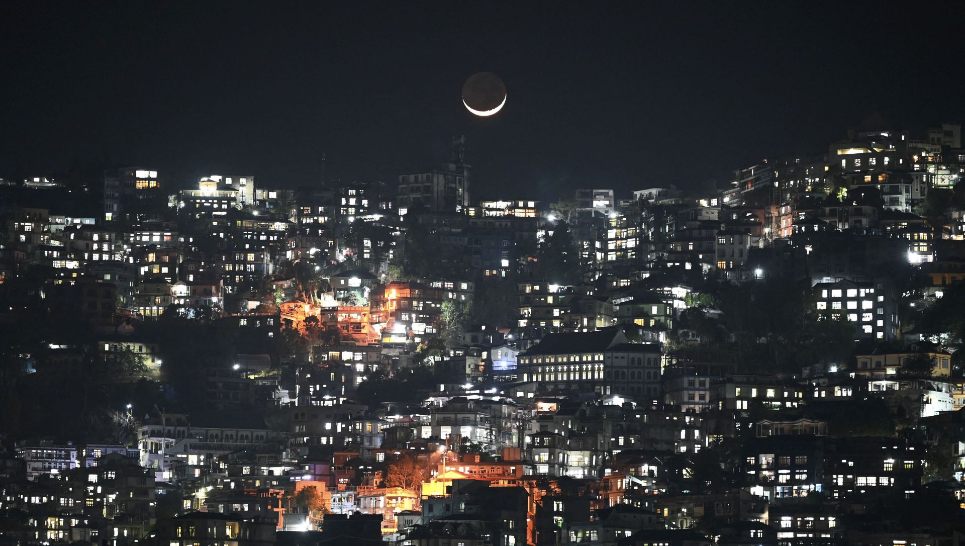 A general view shows a crescent moon over homes on a hillside in Aizawl, the capital of the northeastern Indian state of Mizoram on March 16, 2021 A general view shows a crescent moon over homes on a hillside in Aizawl, the capital of the northeastern Indian state of Mizoram on March 16, 2021 - Sputnik International, 1920, 07.06.2021