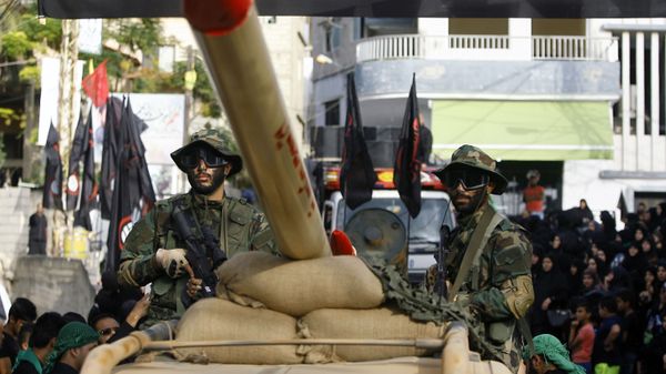In this Sunday, Oct. 9, 2016 photo, Hezbollah fighters stand atop a car mounted with a mock rocket, as they parade during a rally to mark the seventh day of Ashoura, in the southern village of Seksakiyeh, Lebanon. - Sputnik International